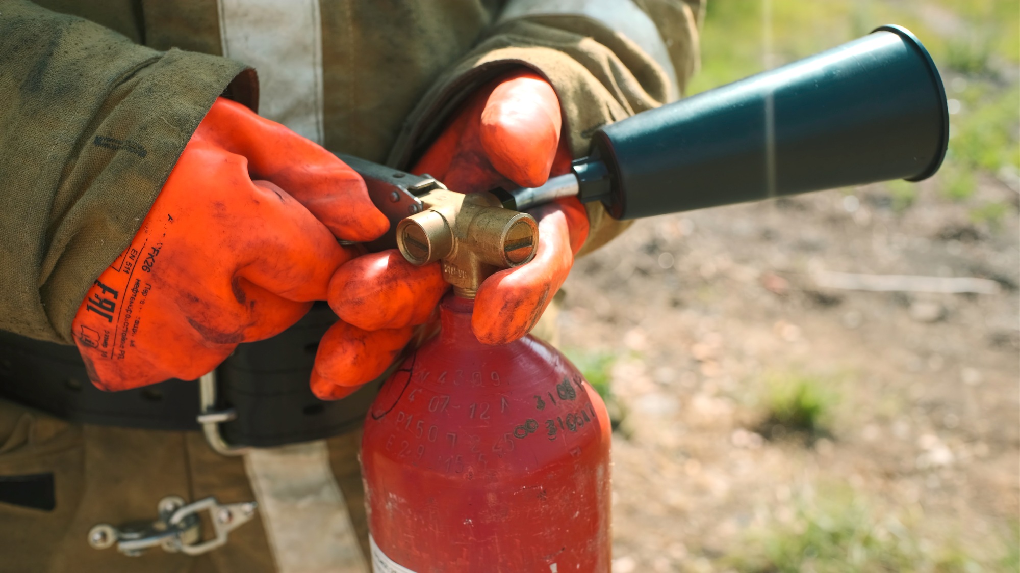 Close-up of firefighter with fire extinguisher. Clip. Firefighter picks up fire extinguisher and